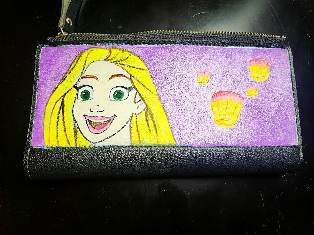 Small dark pouch with a colorful painted character