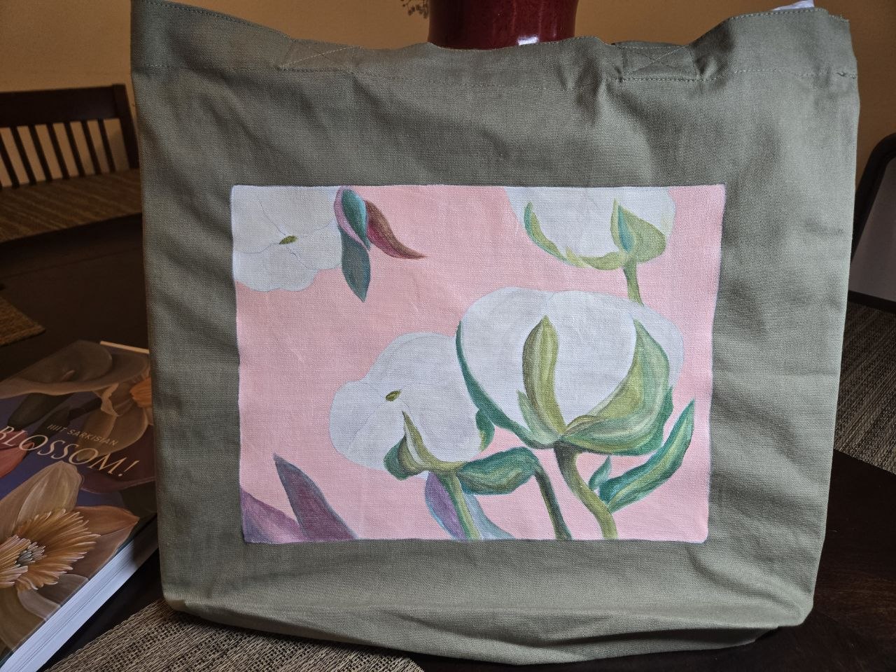 Canvas tote bag painted with white calla lilies on a pink background