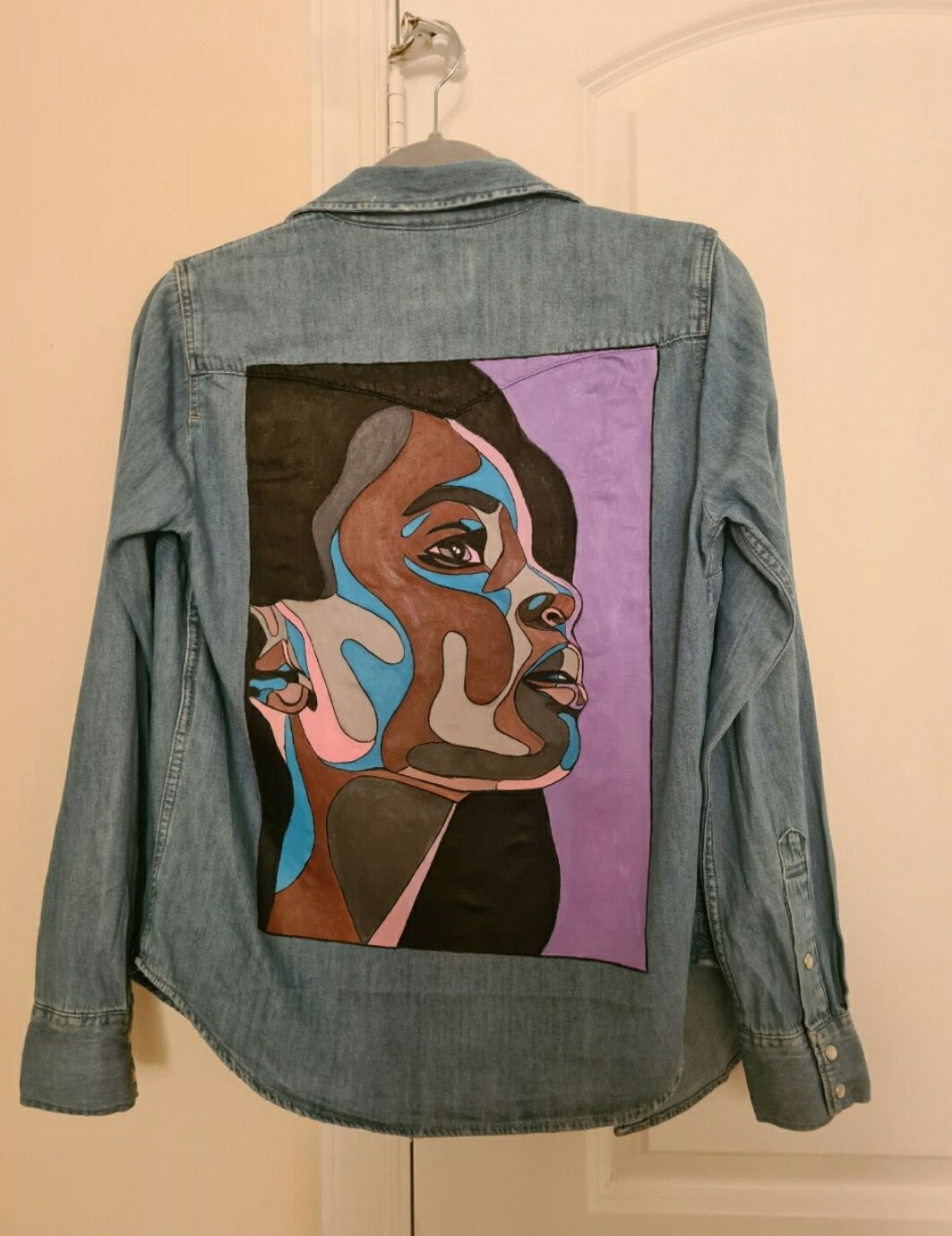 Denim jacket with a colorful hand-painted portrait