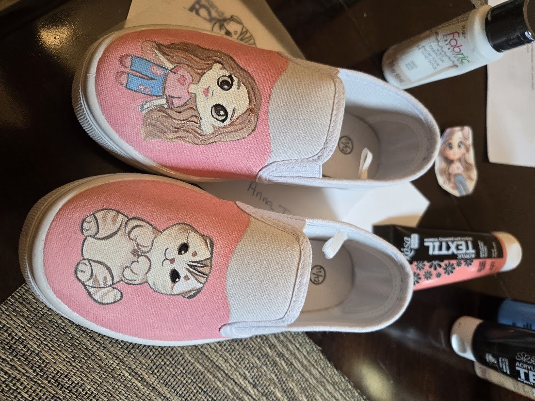 Pink and white slip-on shoes with hand-painted characters