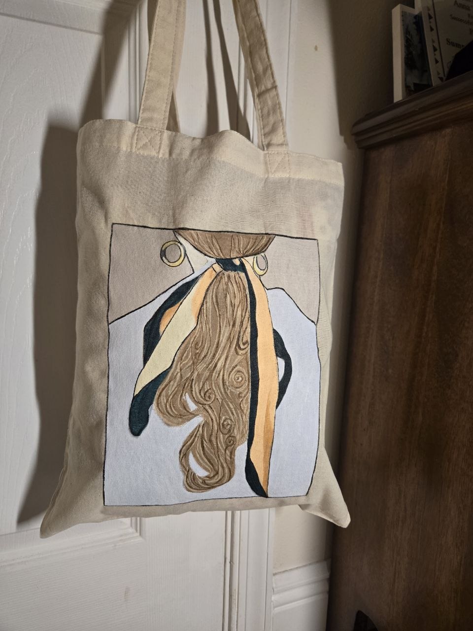 Canvas tote with a painted woman wearing a wide-brimmed hat