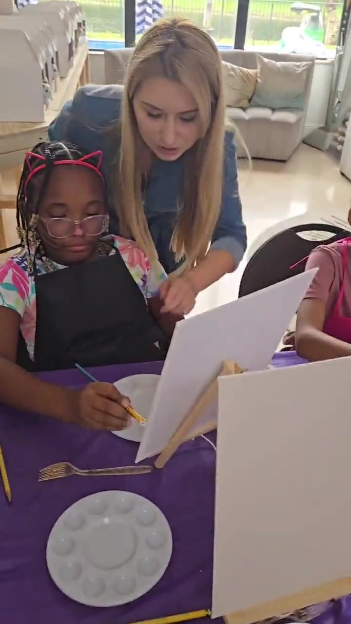 Oksana guiding children through a painting activity
