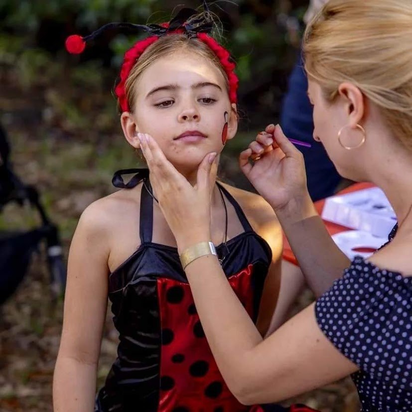 Oksana carefully painting a child’s face at a celebration